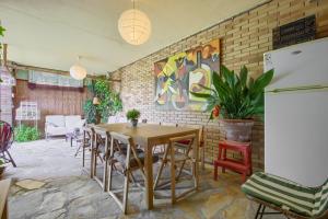 ein Esszimmer mit einem Tisch, Stühlen und einer Ziegelwand in der Unterkunft Casa Serrania in Collado Mediano