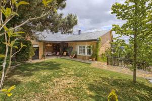 eine Außenansicht eines Hauses mit Garten in der Unterkunft Casa Serrania in Collado Mediano