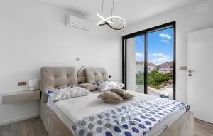 a bedroom with a large bed with a large window at Villa Lux1 Tribunj in Tribunj