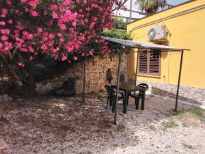 a table and a chair under a canopy with pink flowers at L'oasi in Montesilvano
