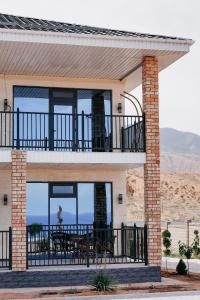 a house with a balcony with a table on it at Hotel Utes in Kaji-Say +54 photos