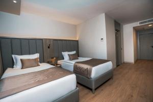a hotel room with two beds and a foot stool at RENEX HOTELS in Antalya