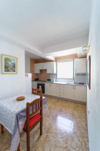 a kitchen with a table and a dining room at Guincho5B in Puerto del Carmen +17 photos