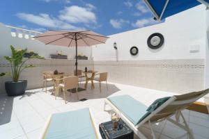 a patio with a table and chairs and an umbrella at Guincho5B in Puerto del Carmen