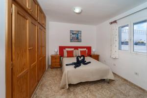 a bedroom with a bed with a black ribbon on it at Guincho5B in Puerto del Carmen