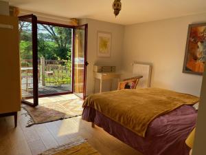 a bedroom with a bed and a sliding glass door at Le Moulin des hirondelles in Pluvigner