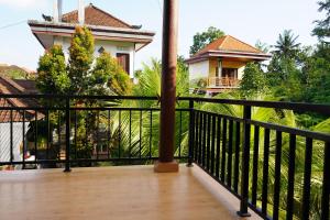 a balcony with a black railing and a house at Central house 2 floor in Ubud