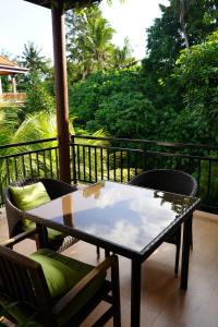 a table and chairs on a patio with a view of trees at Central house 2 floor in Ubud