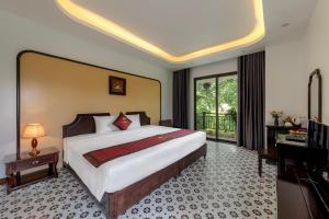 a bedroom with a large bed and a balcony at Le Maison Tam Coc Boutique Hotel in Ninh Binh