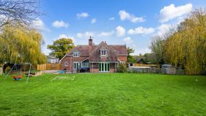 a house with a large yard in front of it at Langford farmhouse - New Forest National Park Luxury 4bd, hot tub, cinema, 10 acres in Bartley