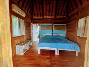 una camera da letto con un letto in una stanza di legno di Villa Bakso Mentigi a Teluknarat