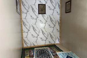 a corner of a room with a white wall with a rug at Family 24 Hotel near Pantai Cipatujah in Cipatujah