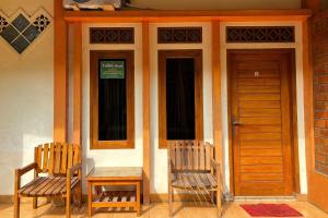 two chairs and a table in front of a building at Family 24 Hotel near Pantai Cipatujah in Cipatujah