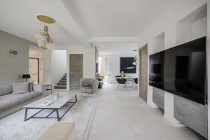 a living room with a couch and a tv at Twin Luxurious Villas 8 BR Pool in Vallauris in Vallauris