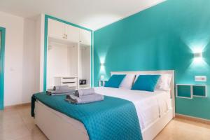 una camera da letto blu con un letto con asciugamani sopra di B-Rent Perla de Mar a Corralejo