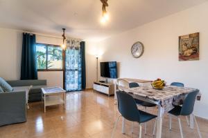 un soggiorno con tavolo, sedie e TV di B-Rent Perla de Mar a Corralejo