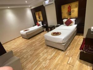 a hotel room with two beds and a couch at أول سويت للشقق المخدومة in Riyadh +21 photos