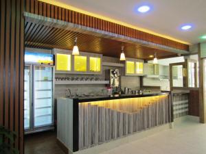 a kitchen with a bar in the middle of it at Paragon Nagoya Hotel Batam in Nagoya