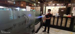 a man wearing a mask standing at a counter at Paragon Nagoya Hotel Batam in Nagoya