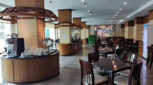 a restaurant with tables and chairs and a bar at Western Grand Hotel Ratchaburi in Ratchaburi