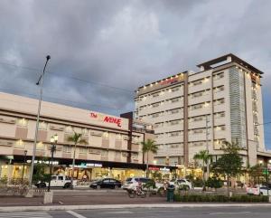 ein großes Gebäude mit auf einem Parkplatz abgestellten Autos in der Unterkunft DIVERSION 21 HOTEL in Molo