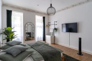 een slaapkamer met een bed en een tv aan de muur bij bevoflats - Live like a local - Apartment in Kreuzberg, Graefekiez in Berlijn