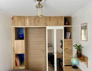 a room with a book shelf with a door at Mosaic Canal - 2 bedrooms flat, 10mn walk to Paris in Pantin