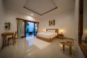 a bedroom with a bed and a table and a desk at Best Place Near City Center and Batu Bolong Beach! - It's A 3BDR Villa with Private Pool in Canggu
