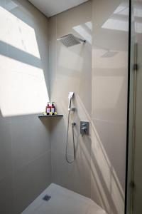 a bathroom with a shower with a glass door at Best Place Near City Center and Batu Bolong Beach! - It's A 3BDR Villa with Private Pool in Canggu +8 photos
