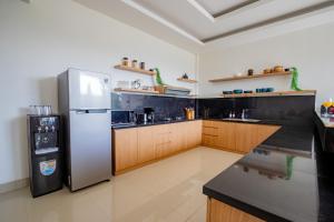 a kitchen with a stainless steel refrigerator and wooden cabinets at Best Place Near City Center and Batu Bolong Beach! - It's A 3BDR Villa with Private Pool in Canggu