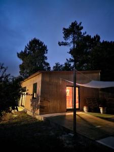 a small wooden building with a tent in front of it at A Cabaña do Cumiar in Ponteareas