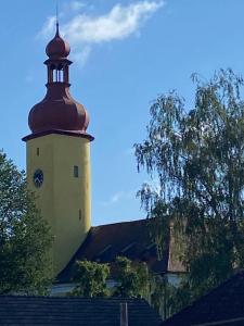 a building with a tower with a clock on it at Ubytování U Jeníka Stráž nad Nežárkou Chlumecká 188 in Stráž nad Nežárkou