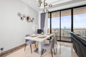 a dining room with a white table and chairs and large windows at Eterna by Kozystay - SCBD in Pondoklang