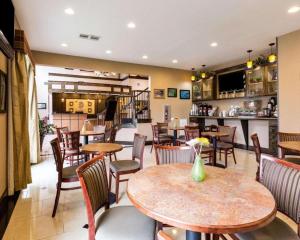 a restaurant with tables and chairs and a bar at Comfort Inn & Suites in Winnie