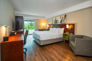 a hotel room with a bed and a desk and a chair at Comfort Inn in Newmarket