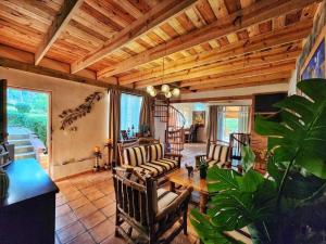 a living room with chairs and a wooden ceiling at La cumbre villages in Básima