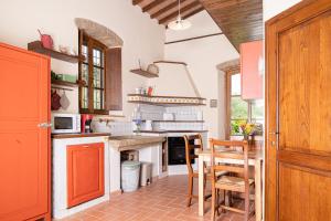 a kitchen with a table and some chairs in it at La Capanna di Montauto in San Gimignano +7 photos