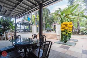 eine Terrasse mit einem Tisch und Stühlen und einem Haufen Bananen in der Unterkunft Quezon Premier Hotel - Candelaria in Candelaria