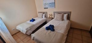 two beds in a room with blue bows on them at Apartamento vacacional Fuerteventura 1B in Cotillo