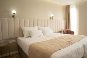 Un dormitorio con una cama grande con sábanas blancas. en Lala, en Bosanska Krupa