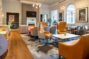 a restaurant with chairs and tables and a fireplace at The Queen at Chester Hotel, BW Premier Collection in Chester