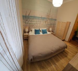 a bedroom with a large bed with blue pillows at Baltic Swans - Apartment in Sopot