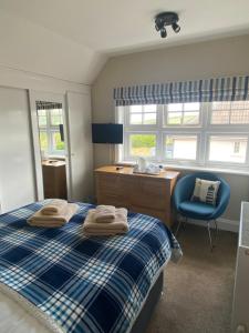 a bedroom with a bed and a desk and a chair at Camberley House in Sheringham