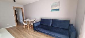 a living room with a blue couch and a table at Apartament nad Sapiną 2 in Kruklanki