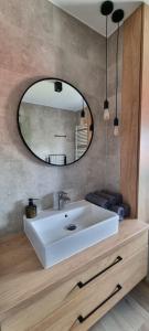 a bathroom with a white sink and a mirror at Apartament nad Sapiną 2 in Kruklanki