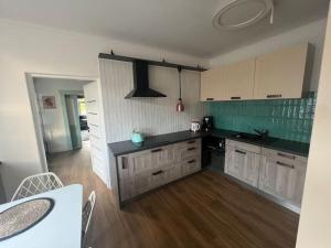 a kitchen with white cabinets and black counter tops at Apartmán Vidiek in Spišská Teplica +2 photos