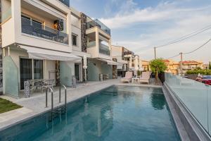 a swimming pool in front of a building with a house at INTERNI LUXURY LIVING b in Nikiti