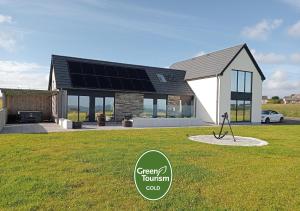 a house with solar panels on the front of it at Flotnar Hús - Newbuild B&B in Keiss
