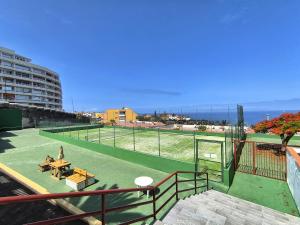 a view of a tennis court with the ocean in the background at TAGARA - 2 pools, ocean view, Puerto de Santiago in Puerto de Santiago