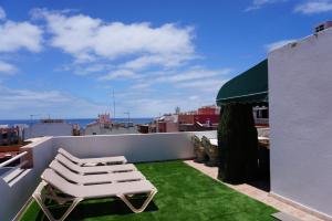 patio z krzesłem i trawą na dachu w obiekcie Viviendas Vacacionales Marcial w mieście Morro del Jable